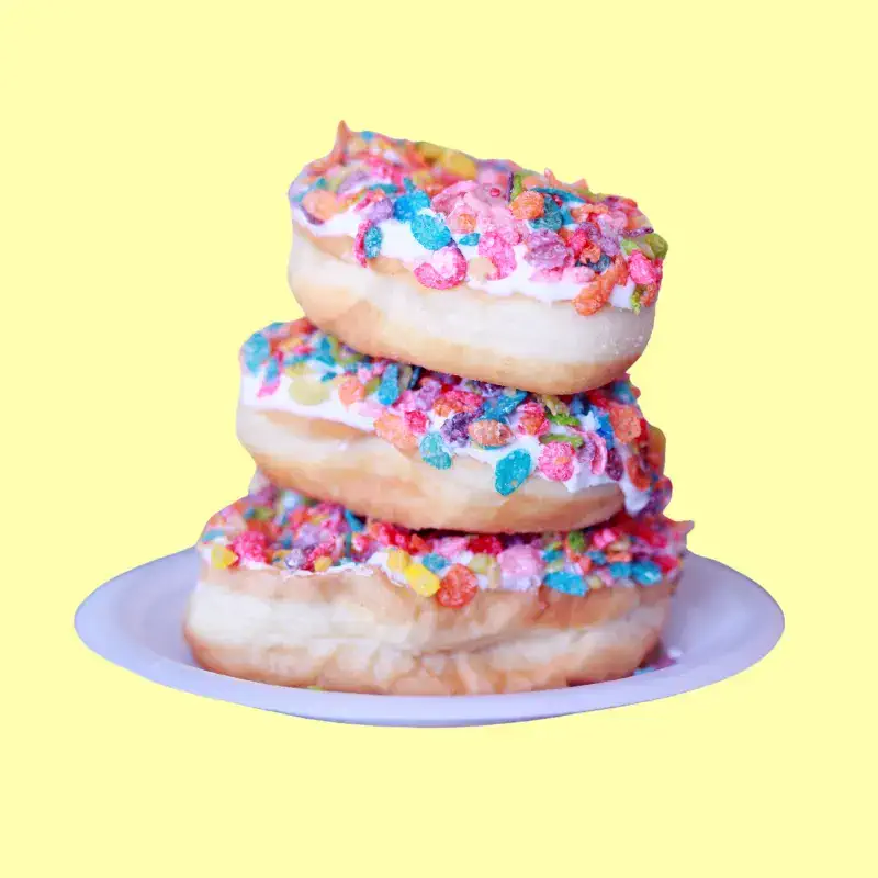 stack of three fruity pebbles doughnuts